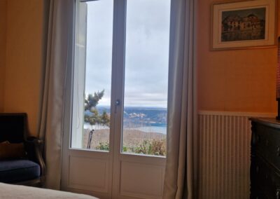 Chambre jaune de la Villa OVerdon avec lit double et vue sur le lac de Sainte-Croix