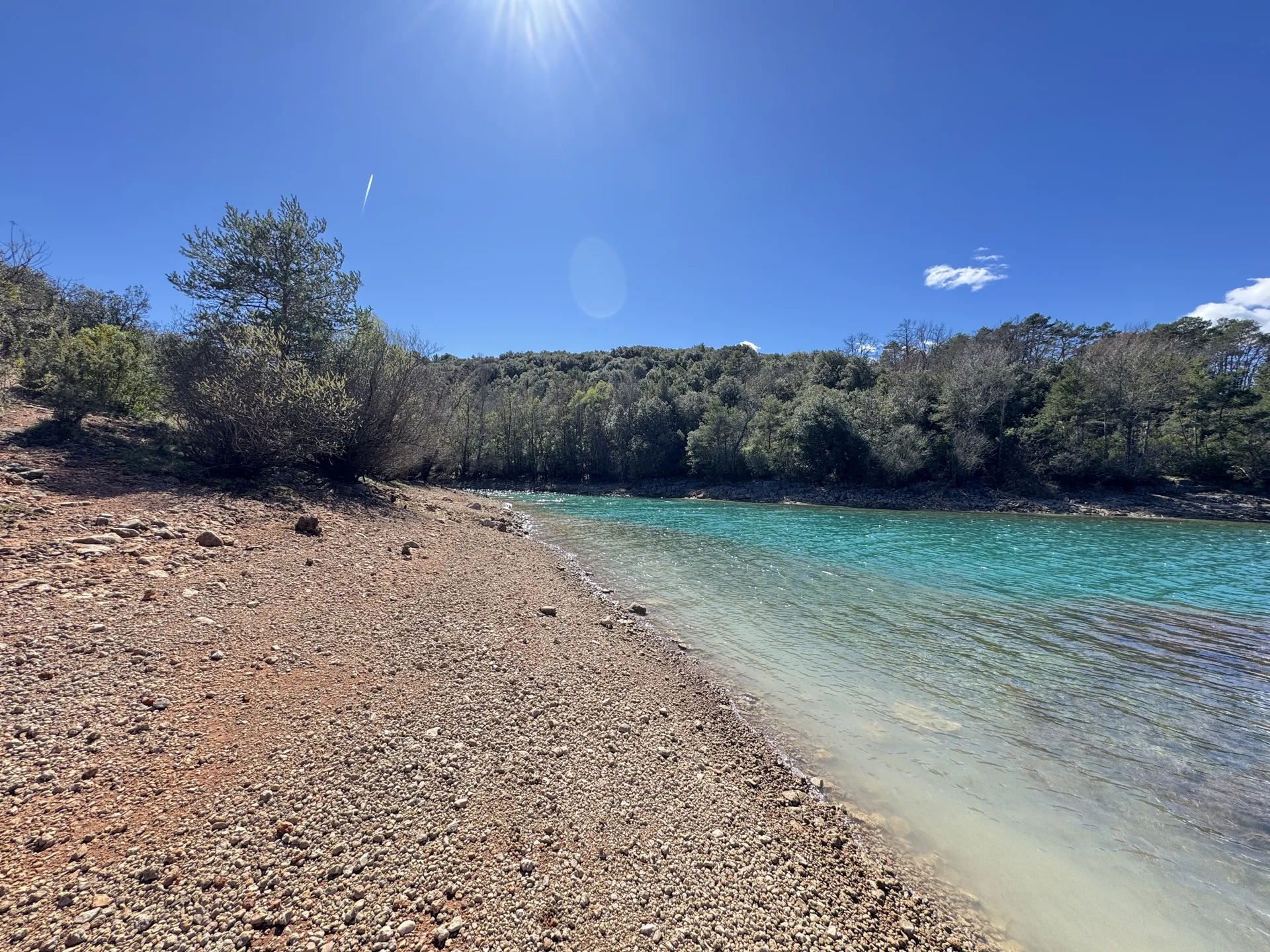 Rive du lac de Montpezat avec soleil et eaux turquoise dans un écrin de nature sauvage Rive du lac de Montpezat avec soleil et eaux turquoise dans un écrin de nature sauvage